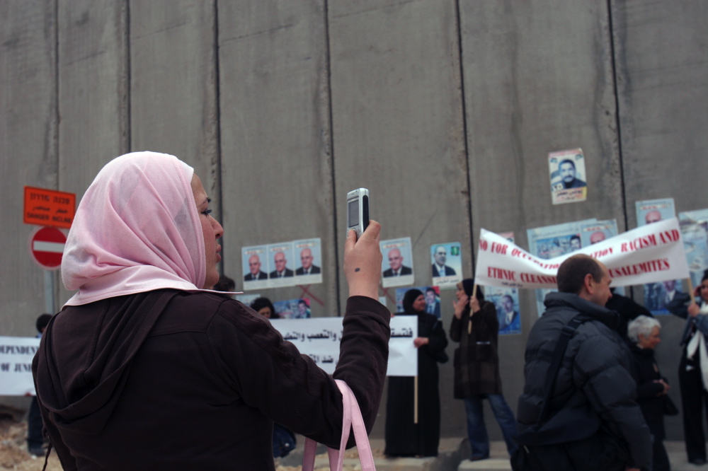Palestinian woman photographing demonstration in Kalandia, Feb 09 06, 04 jpg.